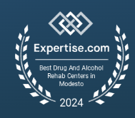 A blue badge with white laurel leaves and text reading "Expertise.com Best Drug And Alcohol Rehab Centers in Modesto 2024," perfect for highlighting achievements in your Elementor footer.